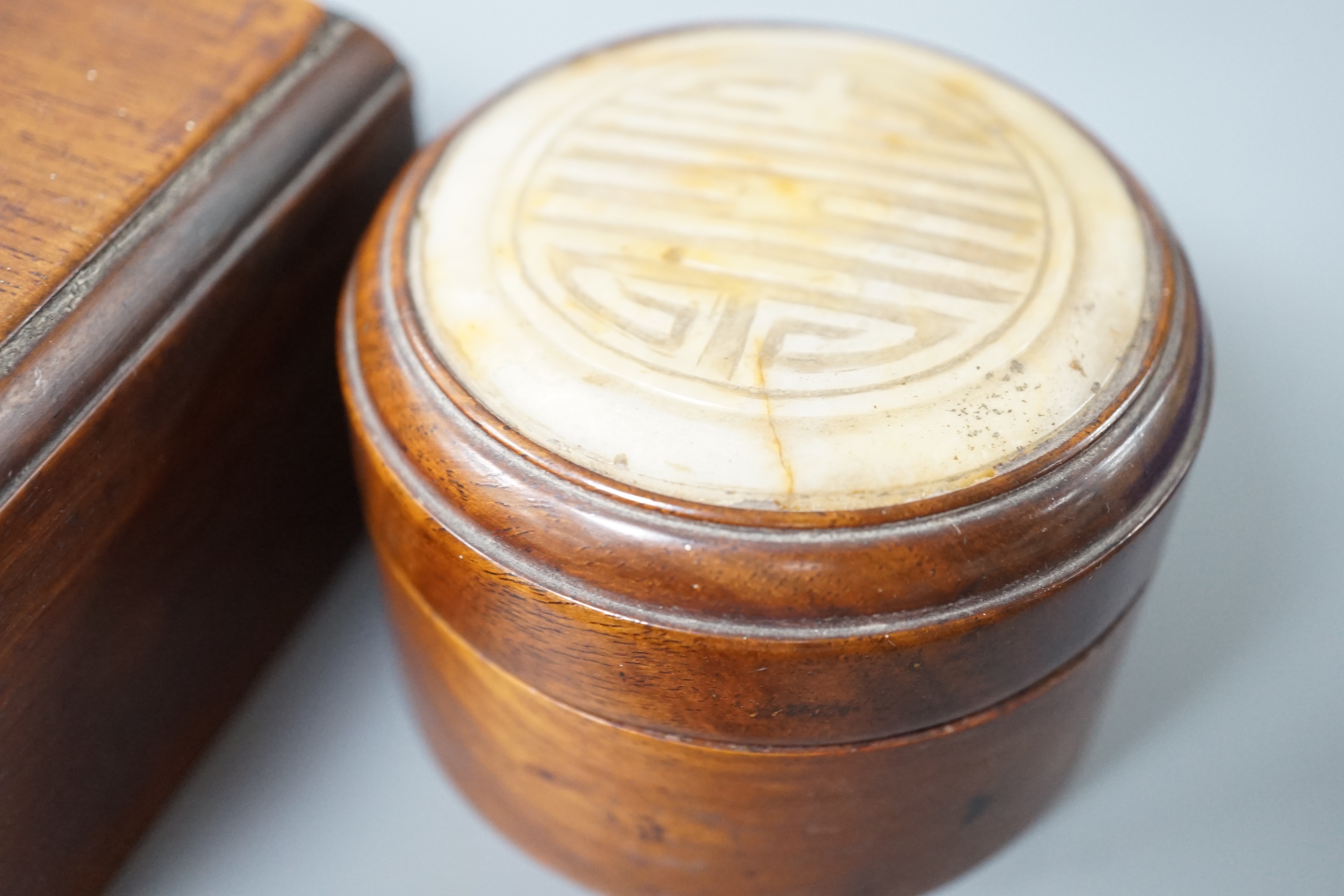 Two 19th century Chinese hardstone inset hardwood boxes and an embroidered amulet charm, largest box 12.5cm